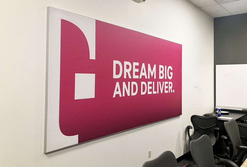 Custom SEG fabric frame with T-Mobile magenta branding and Dream Big and Deliver messaging in a corporate conference room produced by SuperGraphics