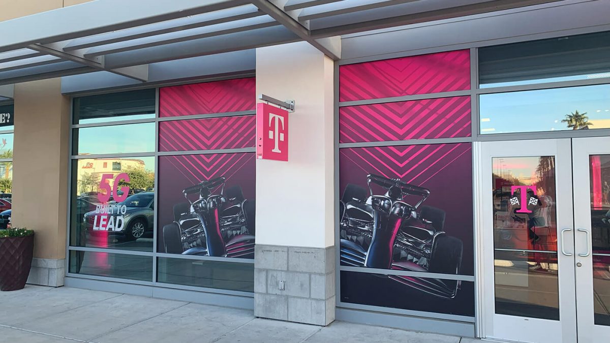 Storefront window graphics for T-Mobile and F1 collaboration. Showcases colorful graphics of F1 car on front of T-Mobile store.