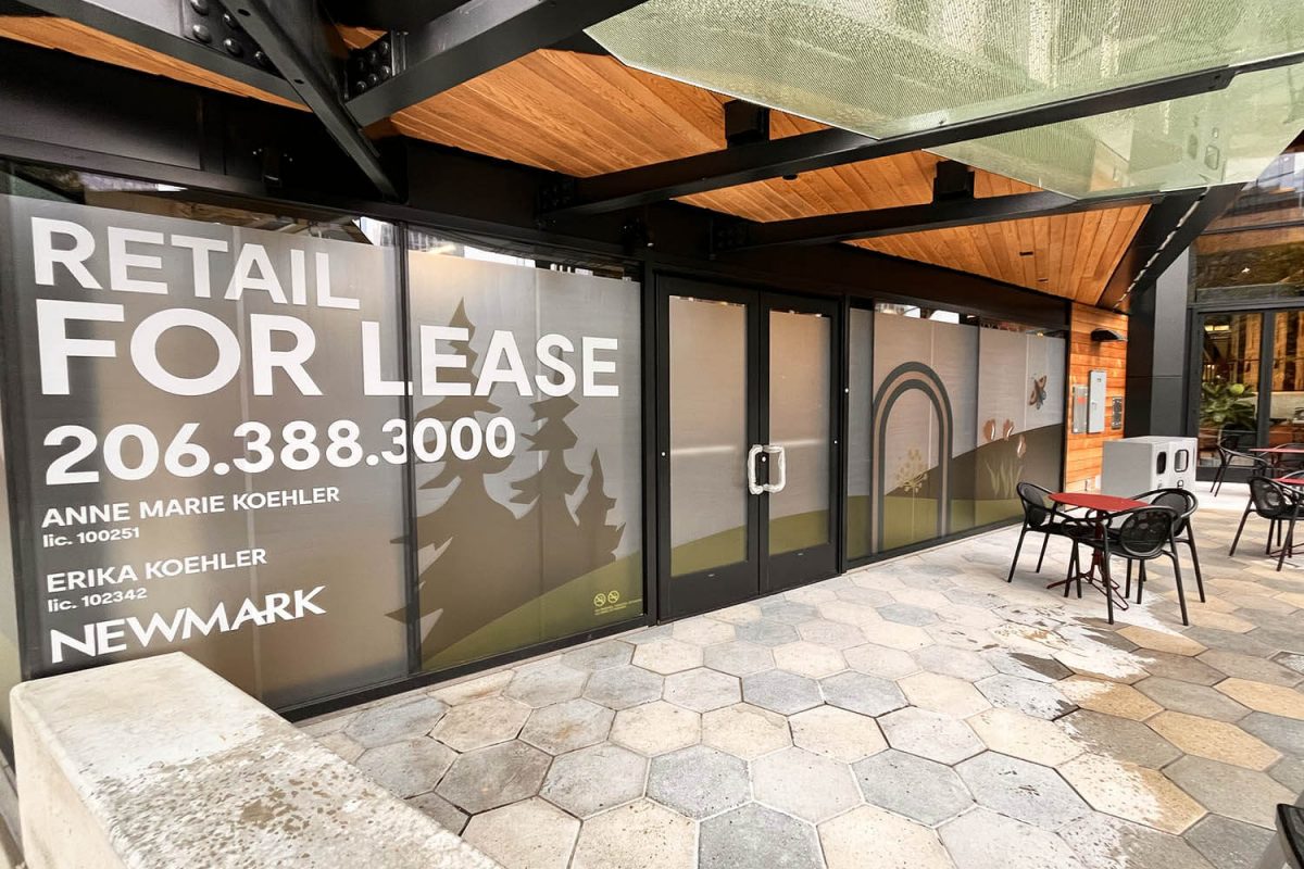 Large retail storefront windows covered with custom “For Lease” graphics and branded frosted vinyl artwork.