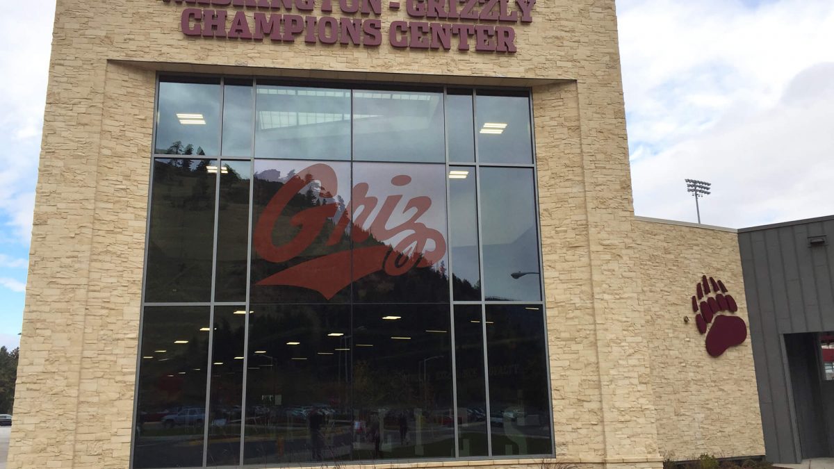 University of Montana Athletics Facility branding, produced and installed by SuperGraphics. Showcases window decal of logo on front entrance, along with dimensional logo iconography and facility name.