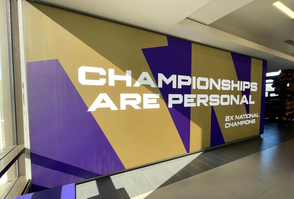 University of Washington Football wall mural, produced and installed by SuperGraphics. Showcases branded graphics of school logo along with messaging, "Championships are personal."