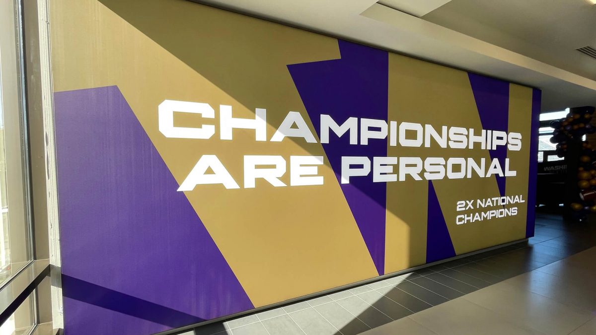 University of Washington Football wall mural, produced and installed by SuperGraphics. Showcases branded graphics of school logo along with messaging, "Championships are personal."