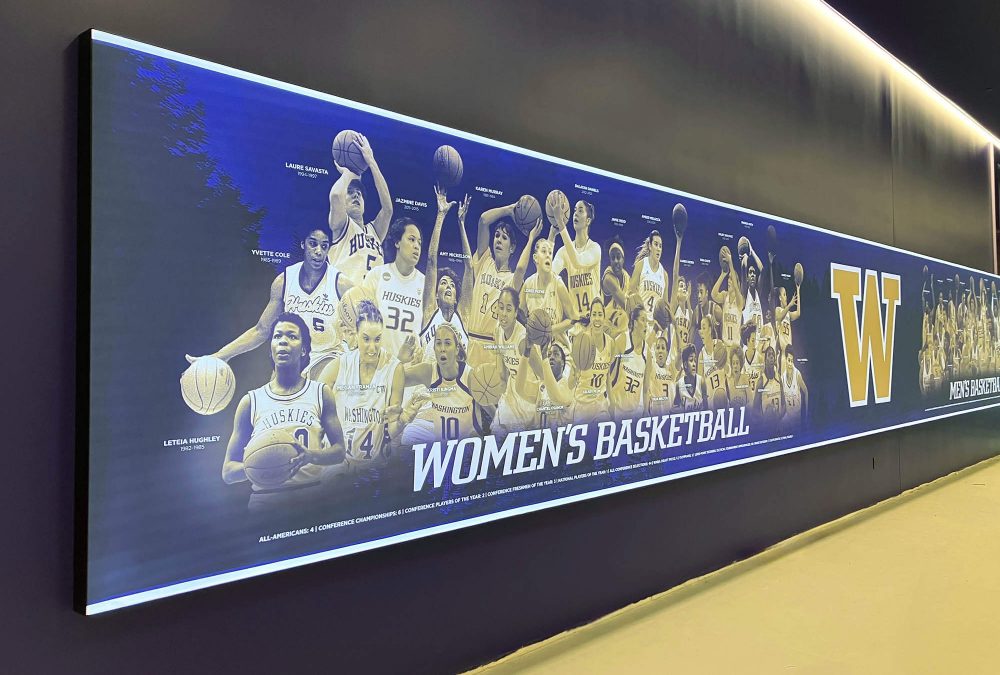 Illuminated SEG graphic featuring historic University of Washington women’s basketball players installed along a hallway in the renovated training facility.